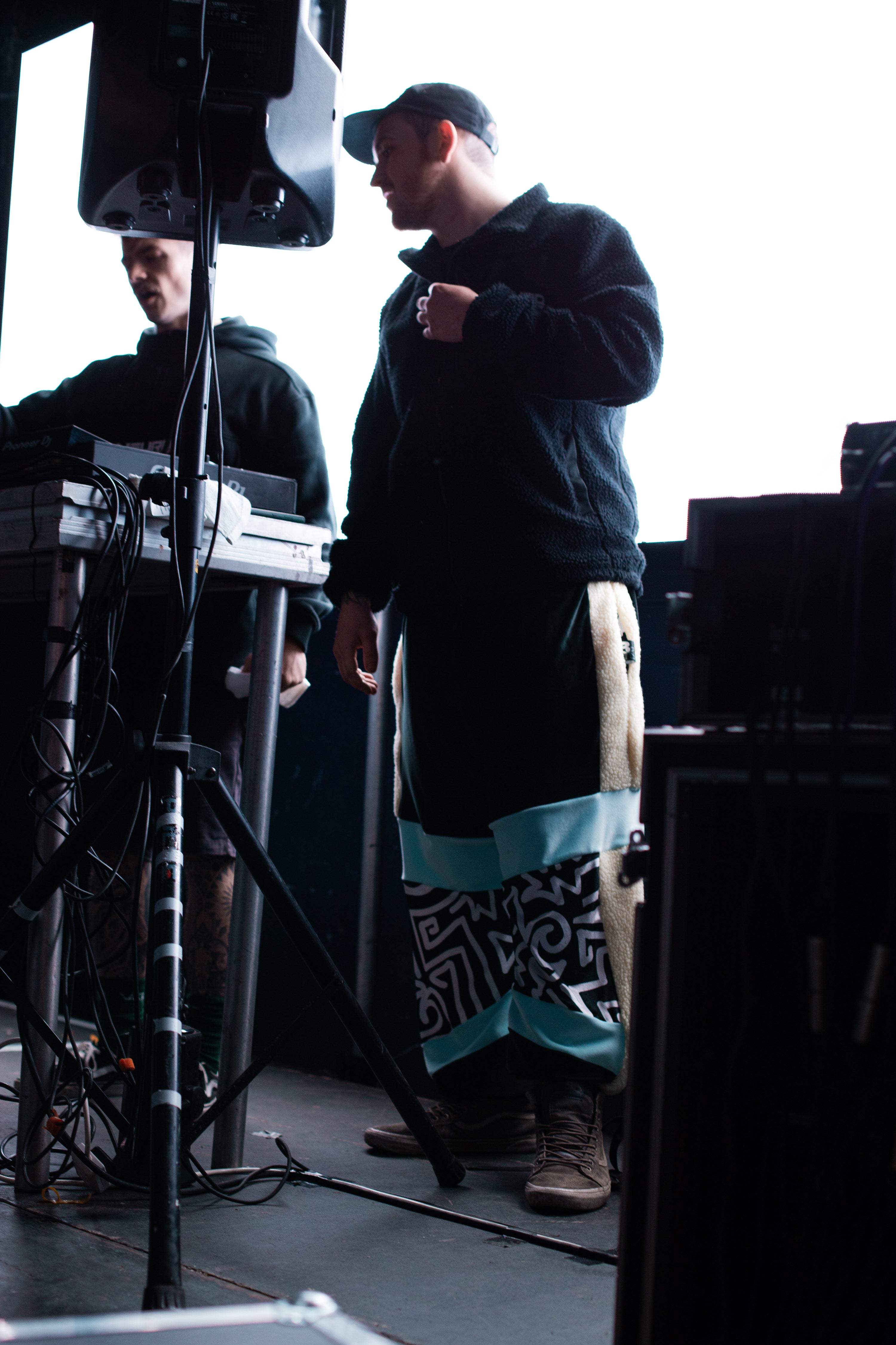 drum and bass label owner wears blue black and white panelled velour funky mens tracksuit bottoms at Lakota nightclub Bristol