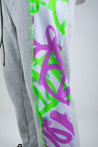 Purple and Neon Green graffiti print panelled grey joggers festival look